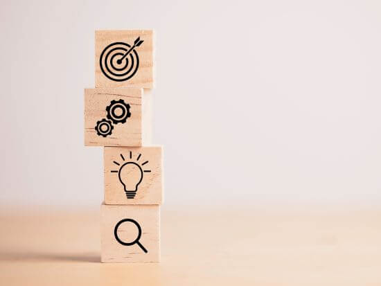 4 wooden cubes depicting business targets, infrastructure and setup, innovation and great ideas